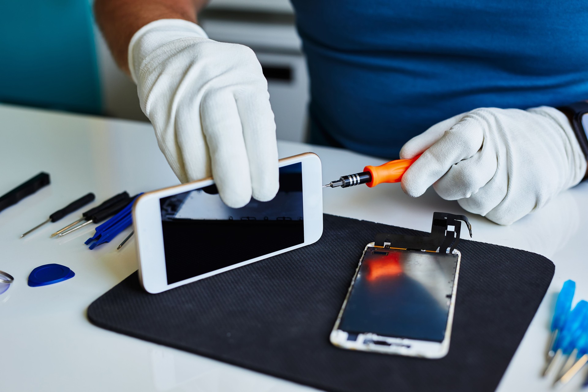 A man repairs a cell phone in a repair shop